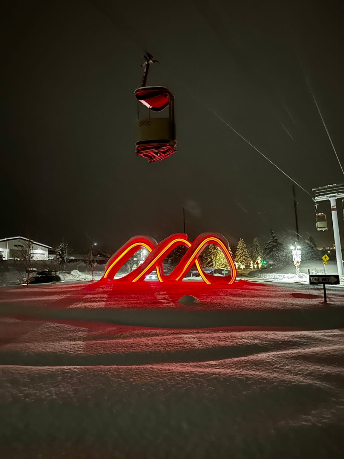 Red-lit gondola installation on a snowy night in Park City